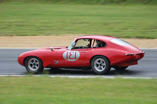 sports car red coupe on roadway during day time jaguar car